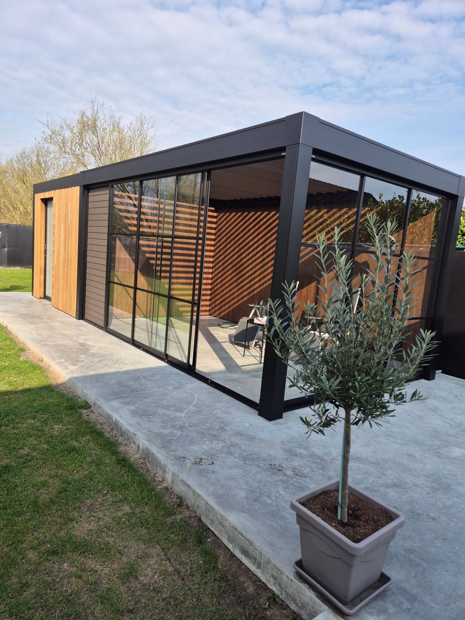 Tuinkamer in Maaseik met lamellendak, steellook schuifwanden en thermowood berging