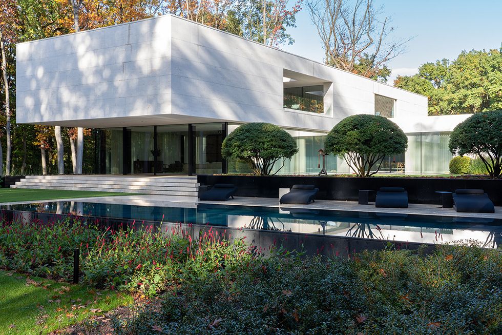 Architecturale villa met natuurstenen gevel en zwembad in harmonie met het landschap