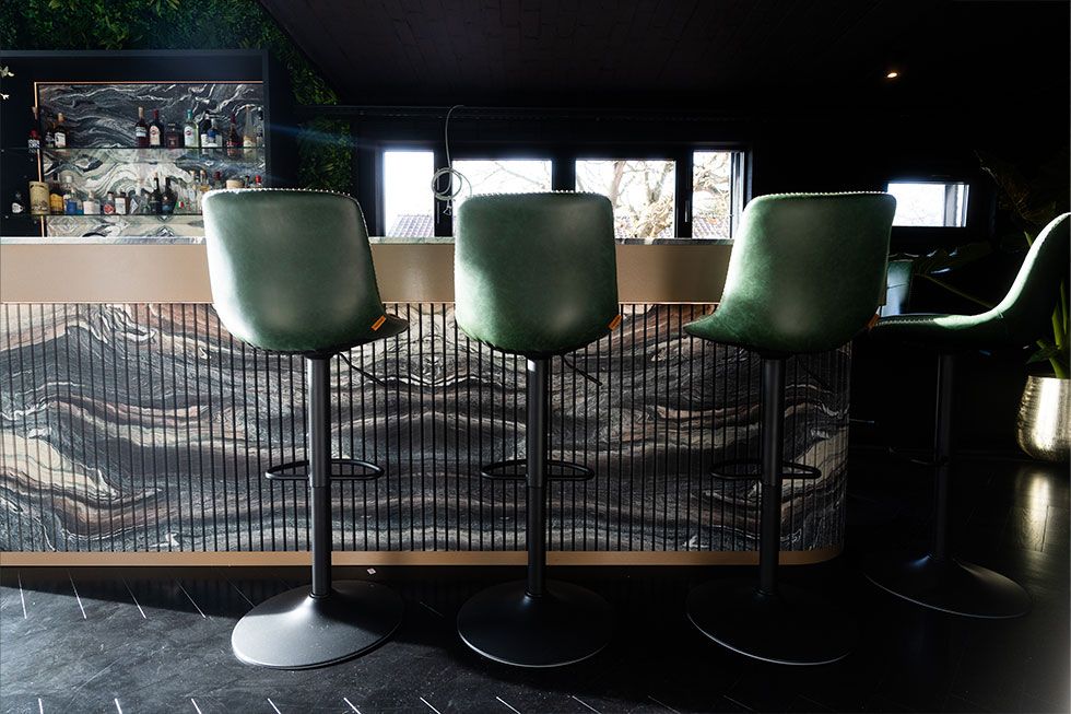 Interieur met natuurstenen bar en zitkrukken in Project T