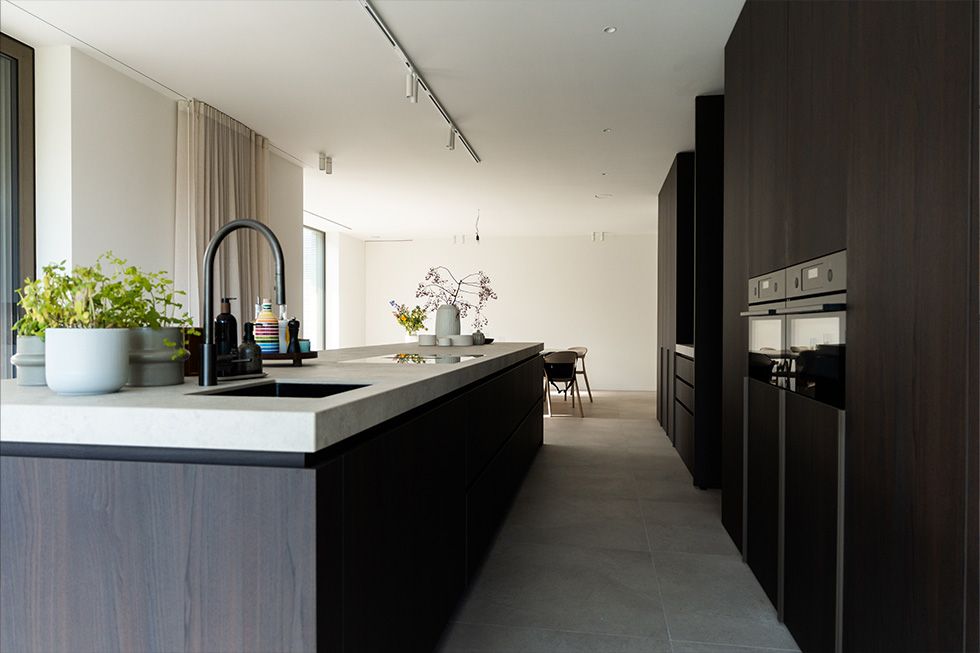 Keramisch keukeneiland en maatwerkkasten in een harmonieus interieur in Project TC Zutendaal