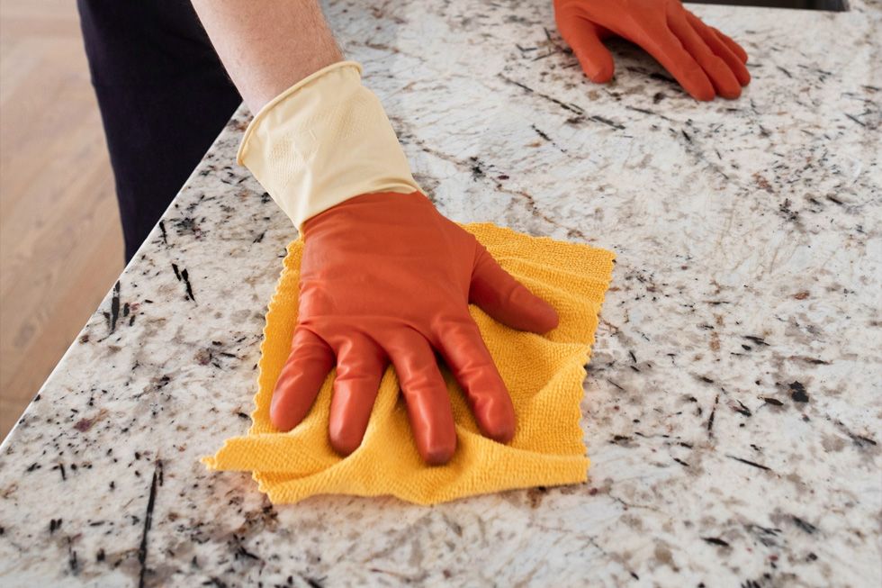 Een keukenblad schoonmaken met een doek: stem het reinigingsmiddel af op de samenstelling van je blad om het oppervlak goed te onderhouden.